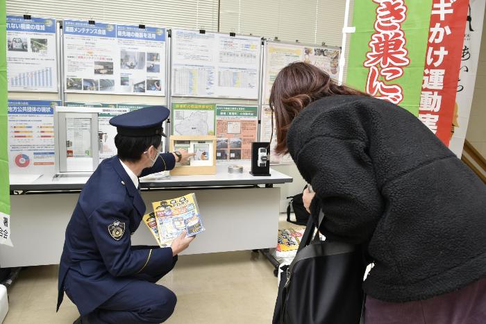 来庁者に補助錠の説明をする警察官