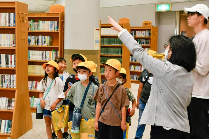 図書館職員から中央図書館について説明を受ける児童