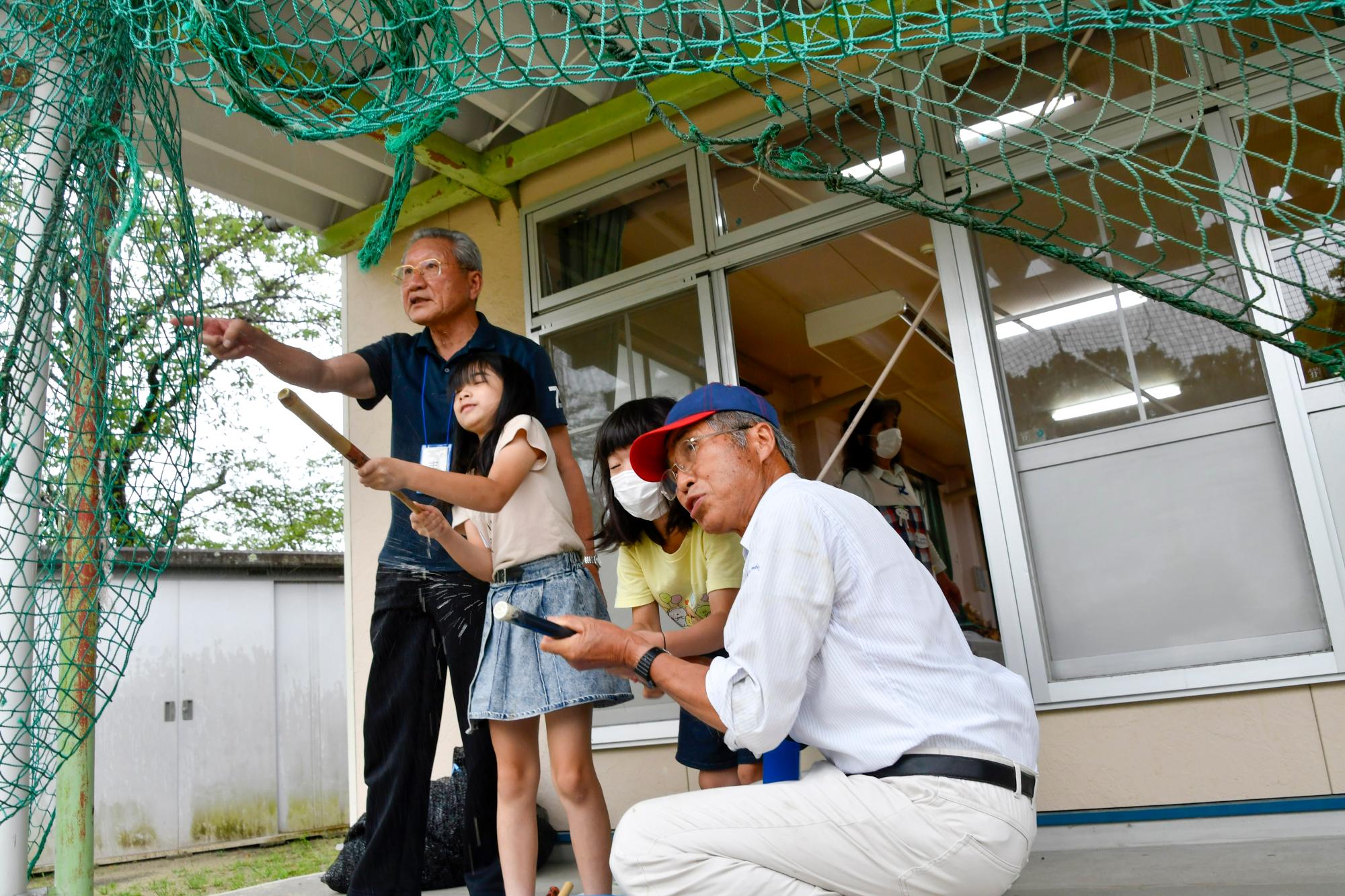 竹でできた水てっぽうを教える講師