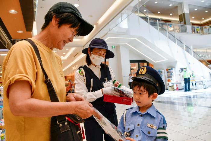 買い物に訪れた方に啓発品を手渡すちびっこ警官