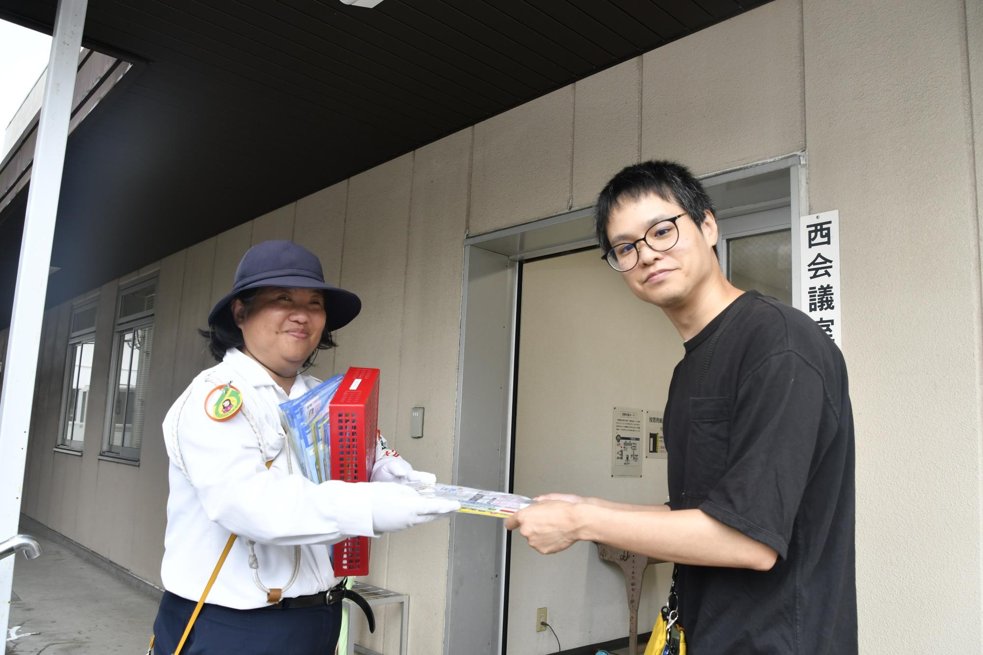 交通指導員から啓発品を受け取る住民