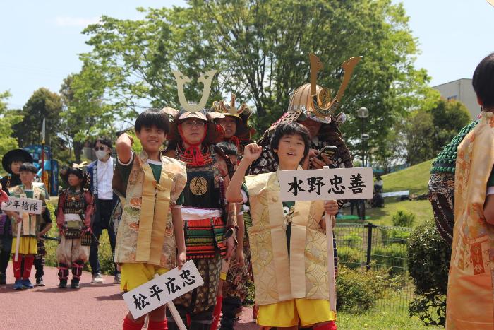 武将のプラカードを掲げる少年たち