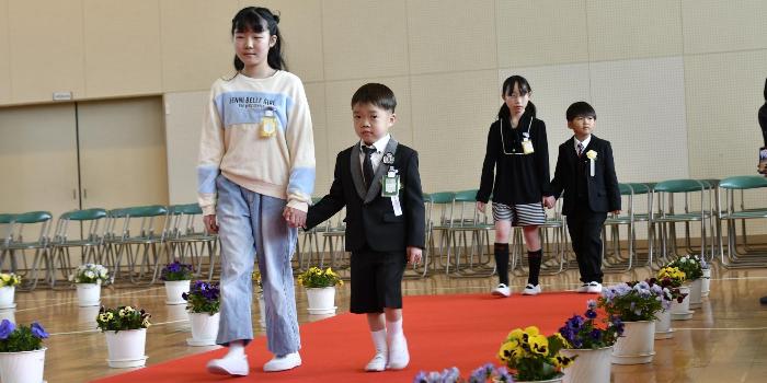 6年生と手をつないで入場する1年生