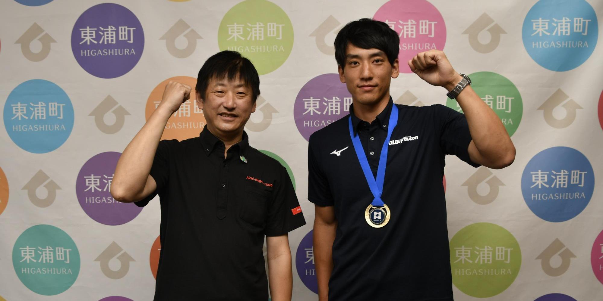 リーグ優勝の喜びをガッツポーズで表現する小塩さん（右）と町長（左）