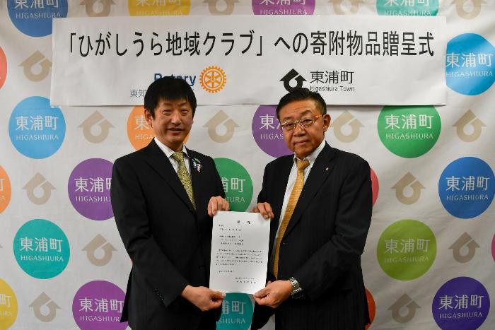 寄付にあたり目録を交わす様子