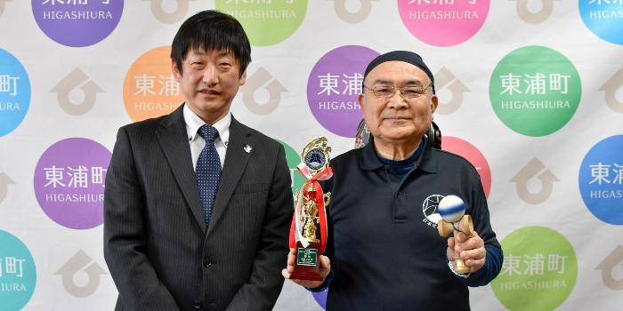 トロフィーとけん玉を手にする尾関さんと町長