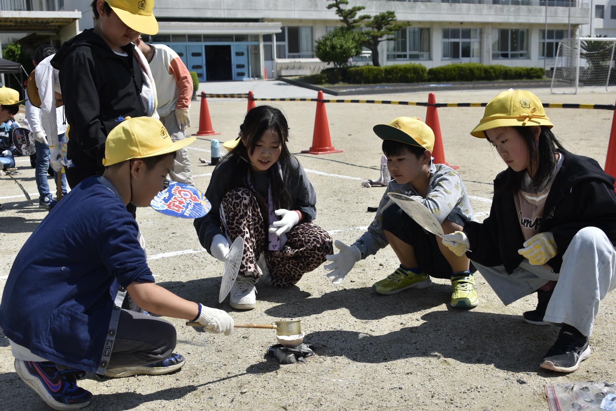手作りの土器に塩水を入れる児童