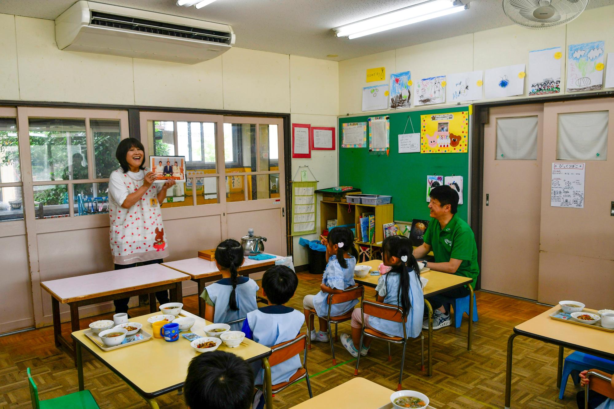 園児の前で収穫米を説明する園長