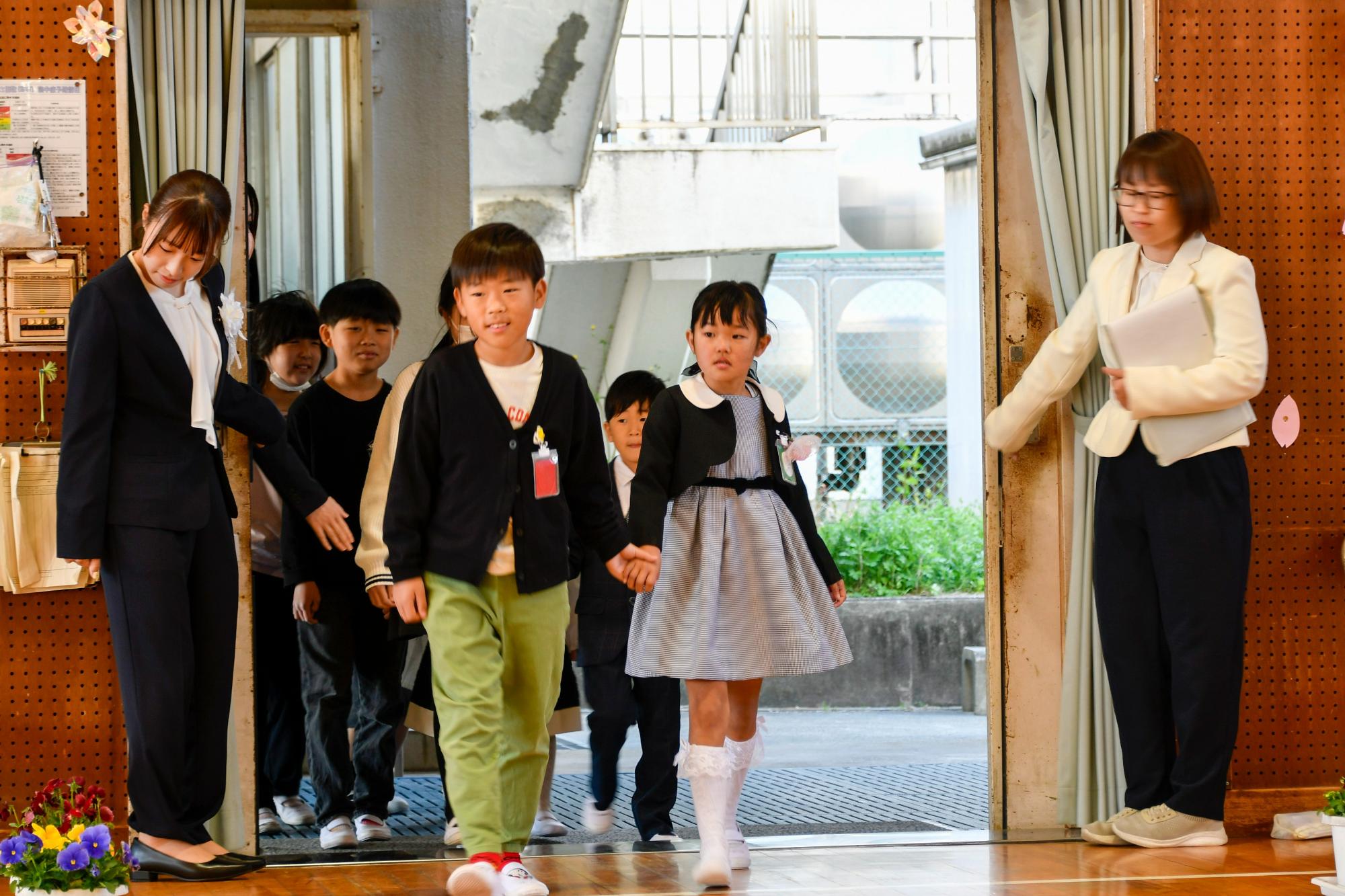 上級生と手を繫いで入場する新1年生