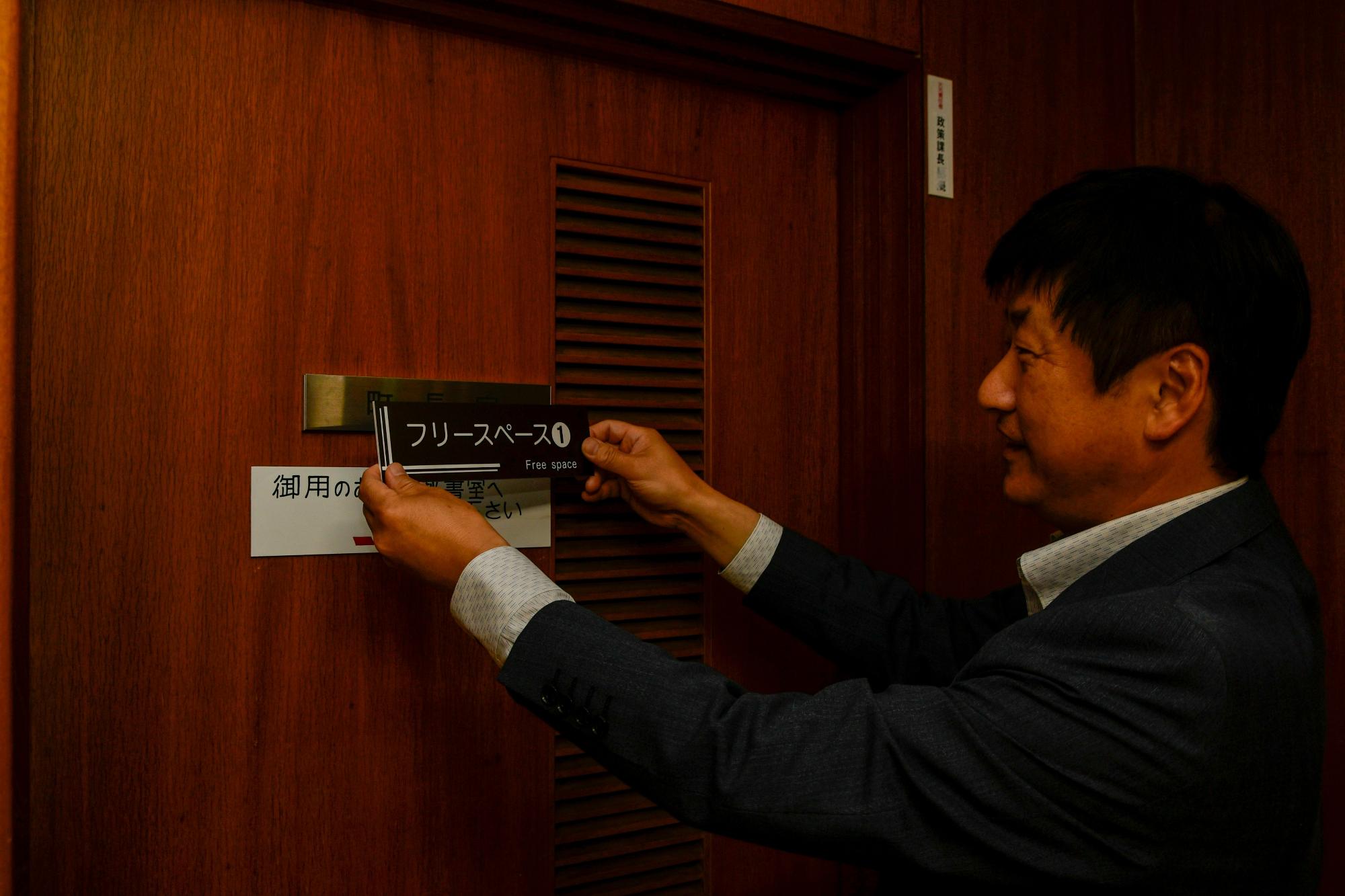 ネームプレートを付け替える町長
